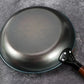Black frying pan on a gray surface