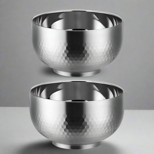 Two silver metallic bowls with a textured surface on a white background