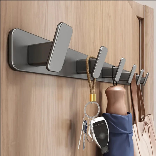 Wall-mounted hook with multiple hooks holding keys, an umbrella, and a bag on a wooden door.