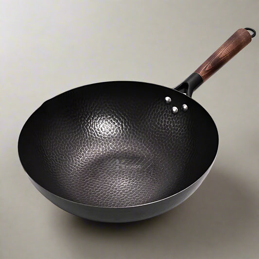 Black wok with a wooden handle on a white background